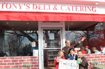 East School students Meredith Sloan, Kiki Brainard and Carolina Welch of Girls Scout Troop 173  pose with Tony's deli owner Tony Gencarelli.