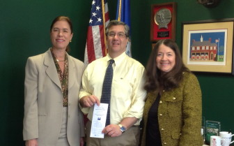 Bankwell in New Canaan President Heidi De Wyngaert (left) and Anne Ward, LWVNC KYR Chair (right), present the 2014 Know Your Representatives brochure to First Selectman Rob Mallozzi. (Contributed photo)