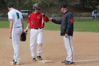 Brandon Abate bumps fists with Rams 1B coach Ron Bentley after hitting a single.