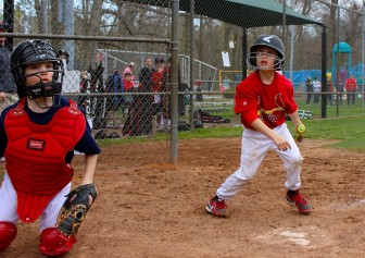 Braves catcher George Stewart follows Henry Silva's foul ball in NC baseball action against the Cardinals.