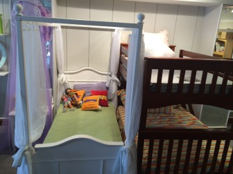 Girl's canopy bed with a trundle on the left, and a twin-over-full bunk bed, at Kids Home Furnishings on Main Street. Credit: Michael Dinan