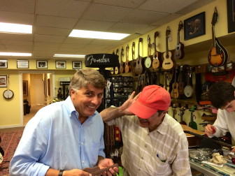 Phil Williams (left) pretends to play a chocolate guitar for friend and co-worker Dan Fiore (right) inside of New Canaan Music. Credit: Alex Hutchins