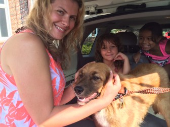 Marianna Mercede, Erica Mercede and Andrea Sandi with the dog that wandered onto the Smith Ridge Lane property of Marianna's mother-in-law on July 25. Here they are bringing the animal to the New Canaan Police Department in hopes of reuniting it with its owner. Credit: Michael Dinan