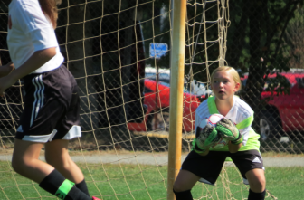 New CanaanU 11 Girls Red team's keeper Kiki Brainard makes a challenging save against East Lyme on Saturday. Contributed photo
