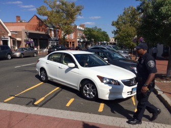 NCPD Community Impact Officer Roy Adams helps a motorist back out of the non-spot at the Playhouse crosswalk on Elm Street. People park there regularly, thinking it's a spot. Credit: Michael Dinan