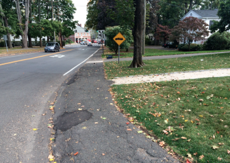 The town is prepared to replace this sorely needed stretch of sidewalk, at the moment nearly at grade with Oenoke Ridge Road/Main Street just below God's Acre. Credit: Michael Dinan