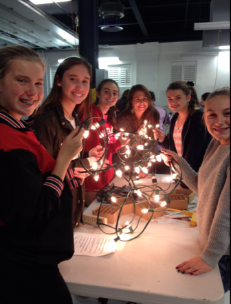 Girls with the National Charity League volunteered to check the lightbulbs that will go into trees downtown for the holiday season. Contributed photo