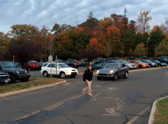 Students crossing the main access road at the New Canaan High School parking lot on the morning of Oc.t 28, 2014. Credit: Michael Dinan