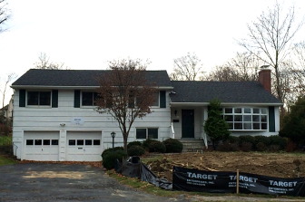 A demolition sign is bolted onto the garage of this 1957 split-level at 66 Field Crest Road in New Canaan, and an application has gone into the town to build a new home that will approximately triple the amount of living space there. Credit: Michael Dinan