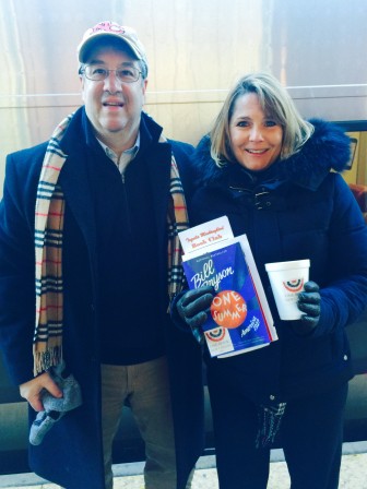 First Selectman Rob Mallozzi and New Canaan Library Director Lisa Oldham gave away copy's of the "One Book New Canaan" selection—Bill Bryson's "One Summer: America 1927"—at the train station for morning commuters on Feb. 11, 2015. Contributed