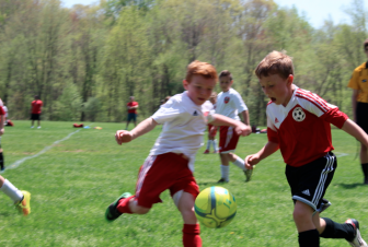 Henry Silva, right, of the New Canaan U9 Boys Red soccer team, beats a Monroe player to the ball. New Canaan defeated Monroe 4-1 on Sunday. Contributed
