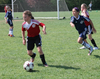 New Canaan Girls U9 Red Soccer team's Kathryn Norton controls the ball as Devon Russell looks on. Contributed