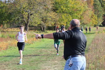 New Canaan Cross Country head coach Bill Martin directs traffic at last year's FCIAC Championship meet at Waveny Park. Credit: Terry Dinan