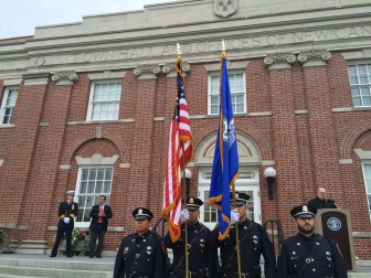 The New Canaan Police Department Honor Guard stands in front of Town Hall while Msgr. William Scheyd of St. Aloysius Church leads the community in prayer during a 9/11 memorial service on Sept. 11, 2015. Credit: Michael Dinan