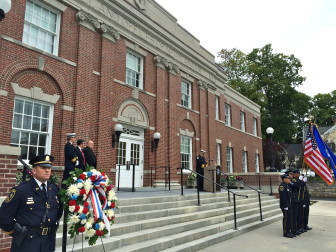 Capt. Vincent DeMaio of the New Canaan Police Department stands in front of Town Hall while Fire Chief Jack Hennessey addresses more than 100 people who gathered for a 9/11 memorial service on Sept. 11, 2015. Credit: Michael Dinan