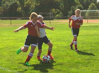 Maggie Murphy controls the ball as Kathyrn Norton looks on during New Canaan's hard fought win over FUSA Red 1 on Sunday. Contributed