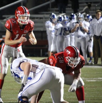Teddy Hood (#58) get set to block for New Canaan QB Michael Collins (#15). Credit: Terry Dinan