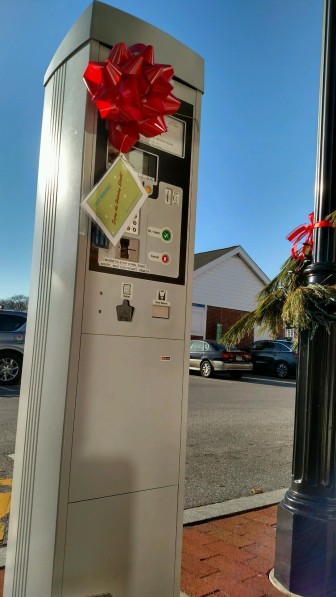A bow and card affixed to this parking meter machine in downtown New Canaan on Friday, Dec. 4 indicates that parking is free. 