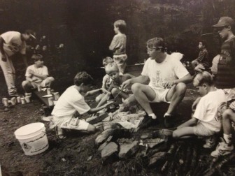Brad Peterson, music counselor, roasting hot dogs with campers in the 1980s at Camp Playland. 