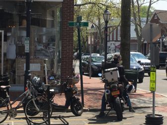 Here is a motorcycle operator parking his vehicle in the area on May 9—a practice no longer allowed by parking enforcement officers. Credit: Michael Dinan