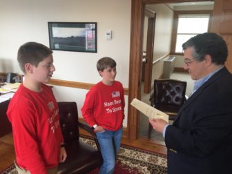 First Selectman Rob Mallozzi reads his letter of congratulations to Saxe Middle School seventh-graders Peter Vigano (L) and Henry Benton (R) in his office on April 28, 2016. Credit: Michael Dinan