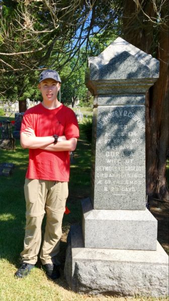 Elliott Ruoff standing next to a veteran's grave at Lakeview Cemetery. Credit: Sarah Maddox