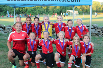 The U11 2006 Girls Red Soccer Team coached by Luke Green proudly displaying their championship medals. Contributed