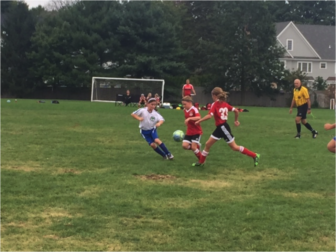 New Canaan’s U10 Mighty Reds drive the ball forward during their victory over Darien Blue, 6-3. Contributed